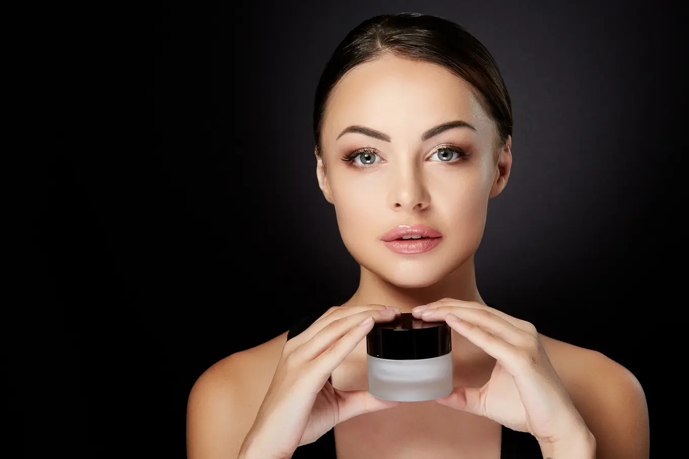 kobieta trzymająca buteleczkę z kosmetykiem